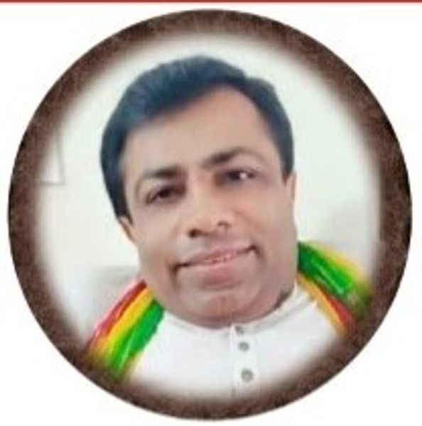 Portrait of a man smiling with a colorful scarf and white shirt.