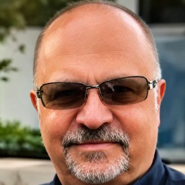 Man with glasses and a goatee smiling.