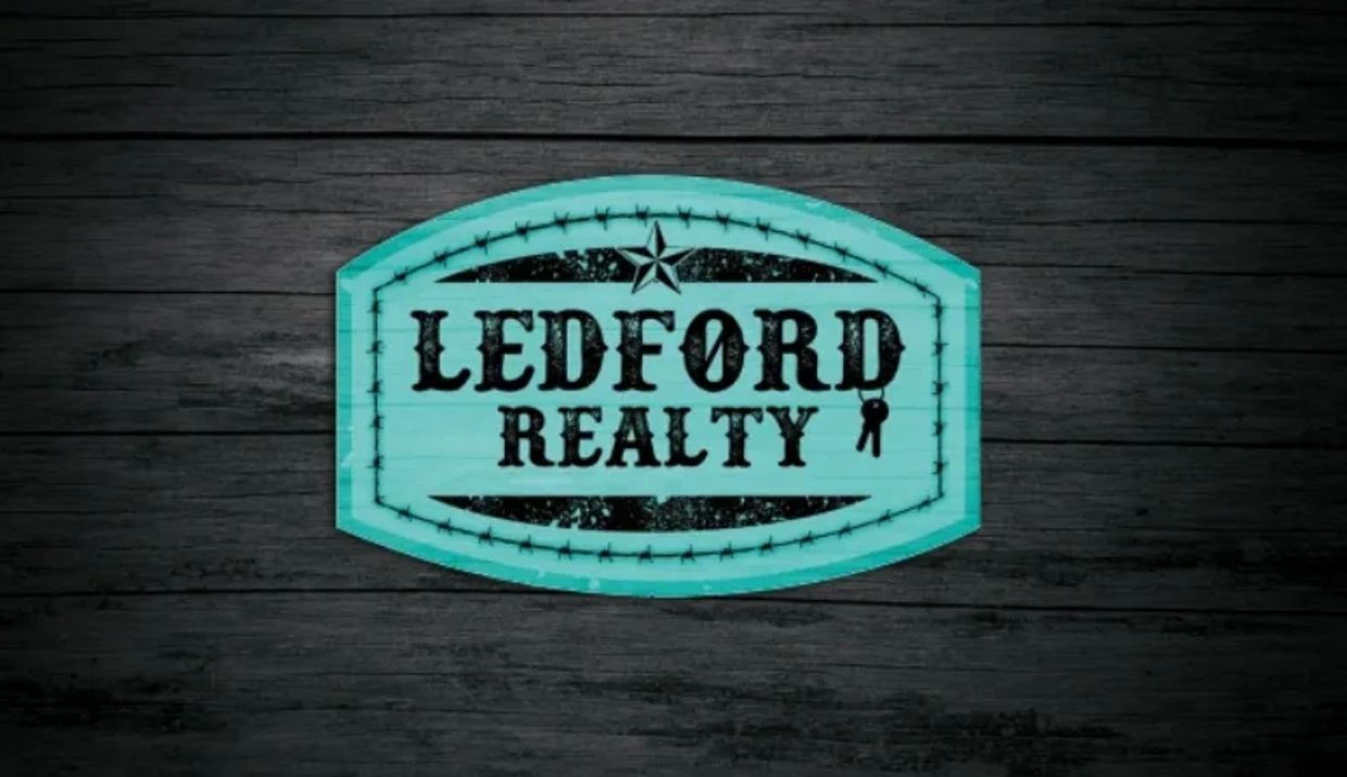 Blue Ledford Realty sign on dark wooden background.
