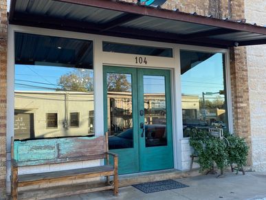 Green double-door entrance with bench and plant.