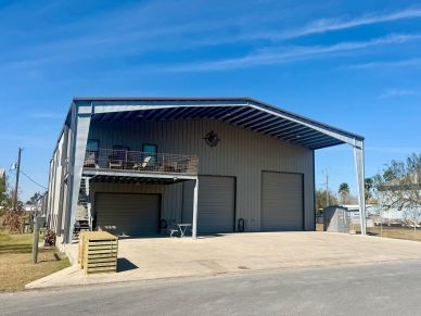 Industrial building with large garage doors and an outdoor seating area.