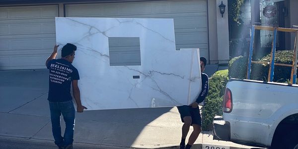 A picture of two men carrying a big tile