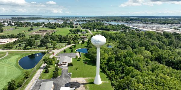 A tall water tower labeled Catawba Island amidst greenery and buildings.