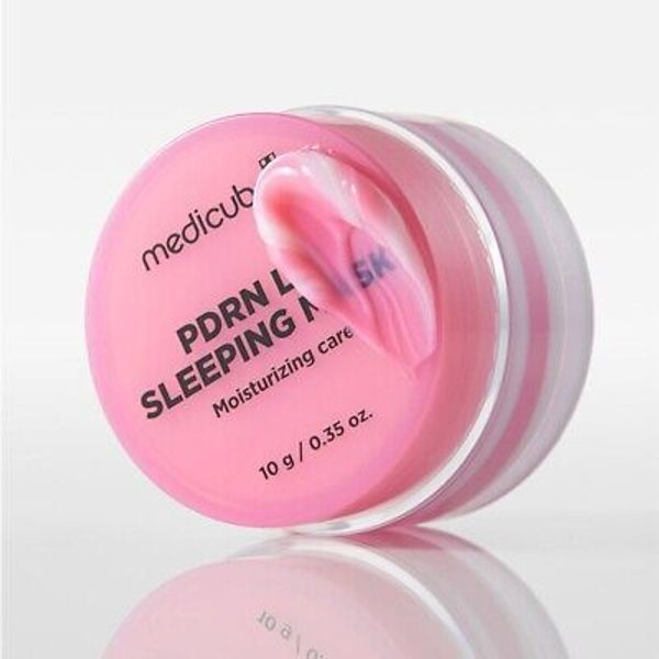 Pink moisturizing sleeping mask cream in a jar with a smooth texture.