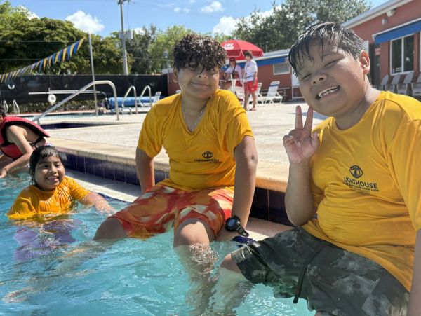 Three kids in yellow shirts enjoying a pool day.