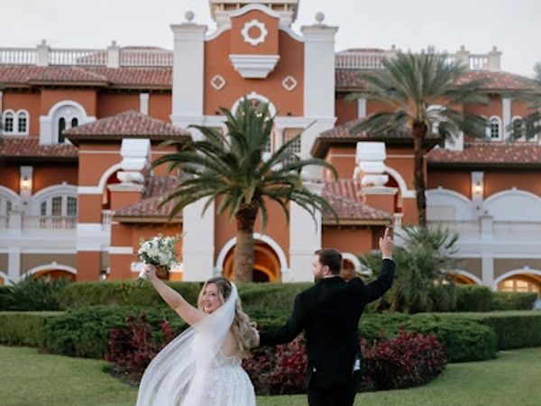 Happy bride and groom outside a large elegant building.