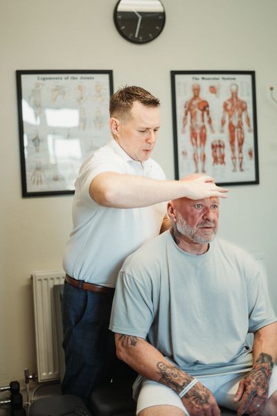 Chiropractor in Tenby assessing neck movement during consultation