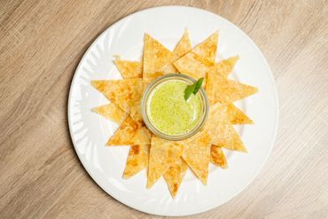 A plate of Nachos and thai green sauce