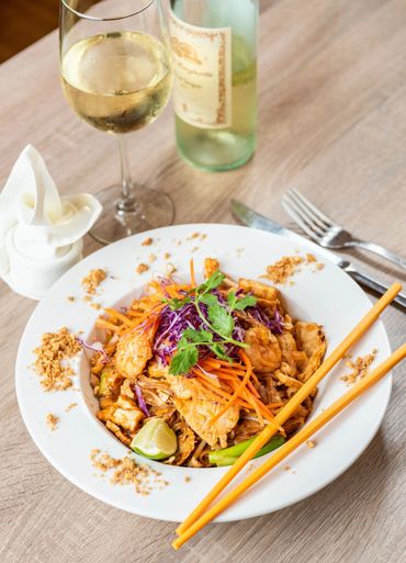 A plate of chicken salad and glass of wine 