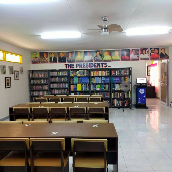 Library room with portraits of presidents above bookshelves.