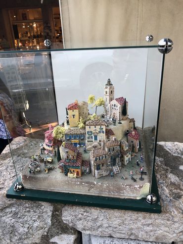 Miniature model of a quaint village in a glass case.