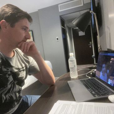 Man video chatting on laptop at a desk.