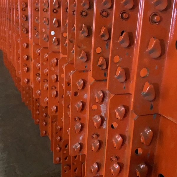 Close-up of orange metal beams with bolts.