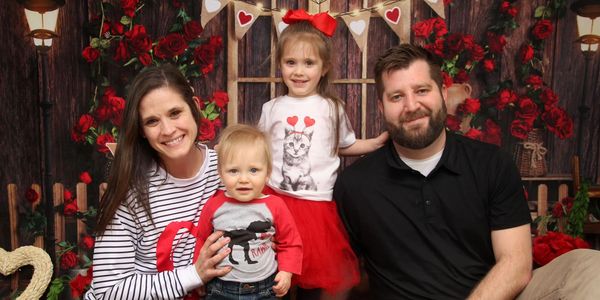 family with mother, father, and two kids smiling at camera