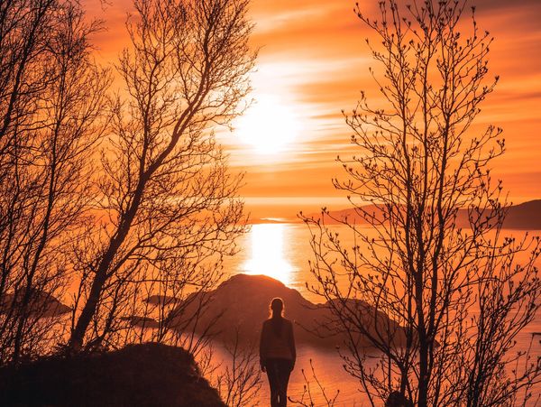 Woman looking at the sunset from mountain