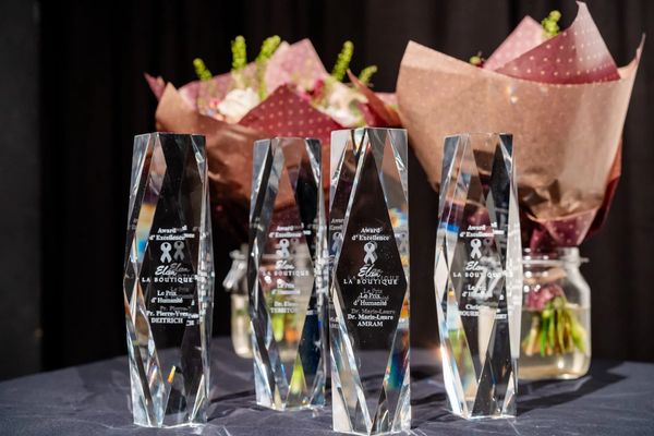 Crystal awards displayed with flower bouquets in the background.