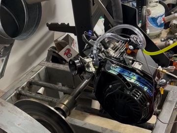 Engine mounted on a test bench with a flywheel.