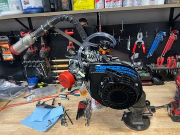 A mechanical engine setup on a workbench with tools.