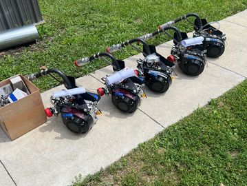 Four miniature engines lined up on a sidewalk.