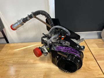 A small engine with a black and purple design on a wooden table.