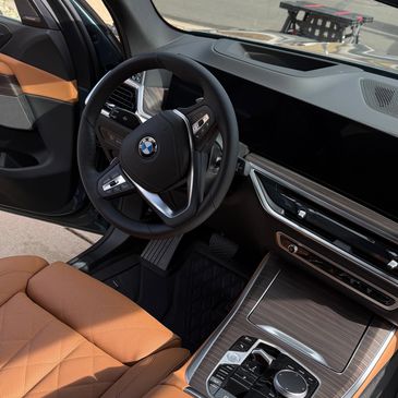 Luxurious BMW interior with tan leather seats and modern dashboard design.