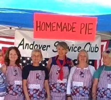 Women in aprons selling homemade pies at a community event.