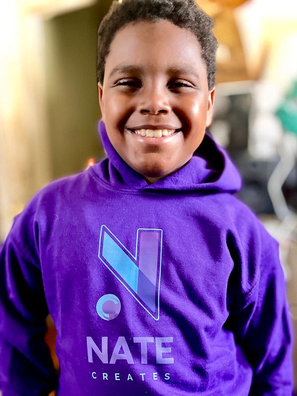 NateCreates™ founder and artist wearing a purple NateCreates™ hoodie available on natecreates.store