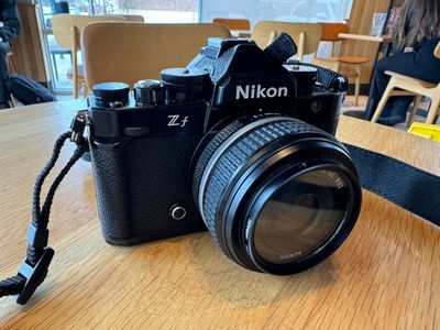 Photo of a Nikon Zf camera on a wooden table.