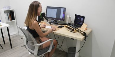Woman recording podcast in a home office setup.