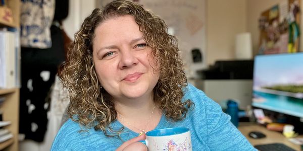 Life Balance and Career Coach Ella smiling with cat mug