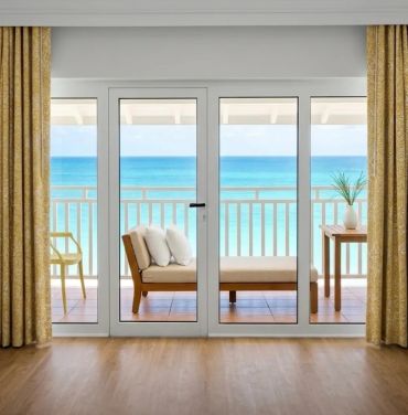 Balcony with ocean view through glass doors.
