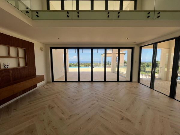 Spacious room with large glass doors opening to a scenic outdoor view.
