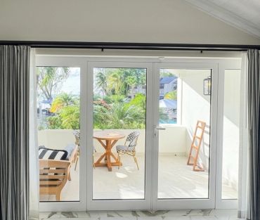 Bright patio with glass doors and outdoor seating.