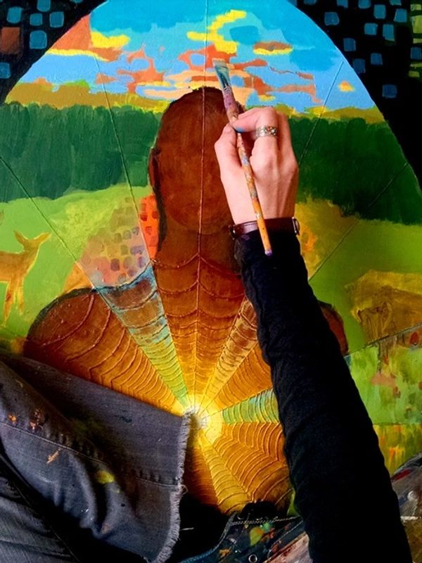 Artist painting a vibrant surreal landscape with a glowing figure and animals.