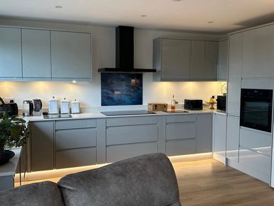 Modern kitchen with grey cabinets and under-cabinet lighting.