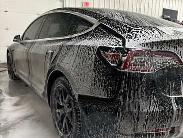 tesla soaking in soap bubbles, exterior detail