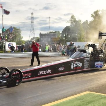 A dragster race car ready at the starting line on a drag strip.