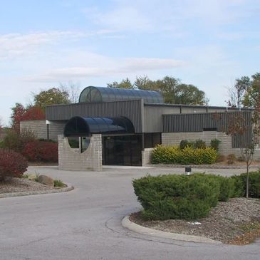 Modern building with a unique circular entrance and landscaped surroundings.