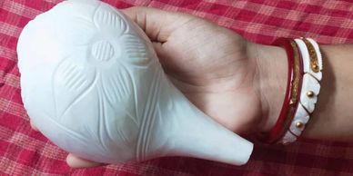 Hand holding a white carved object.