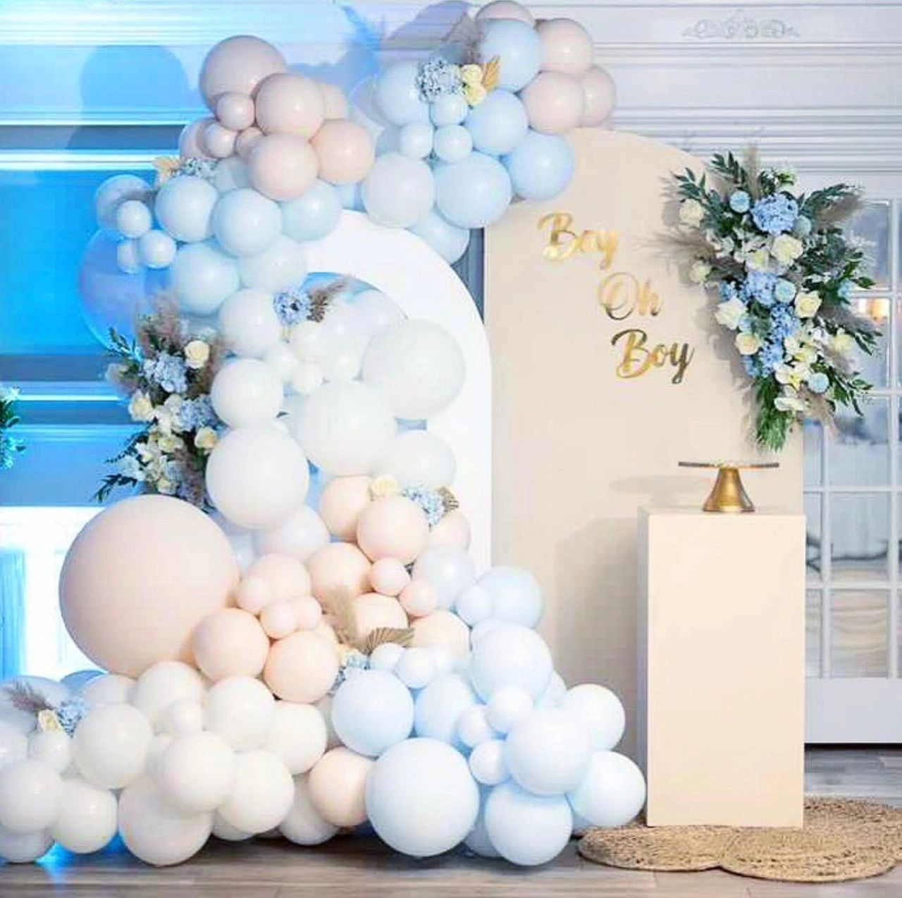 Elegant baby shower setup with pastel balloons and floral decorations.