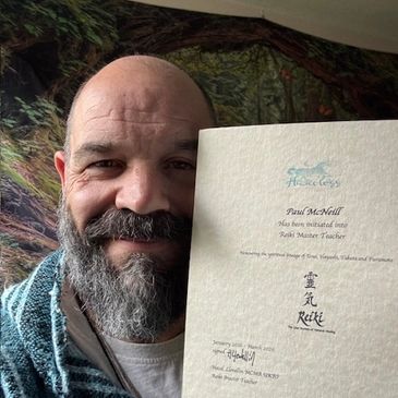 Man proudly holding a Reiki Master Teacher certificate.