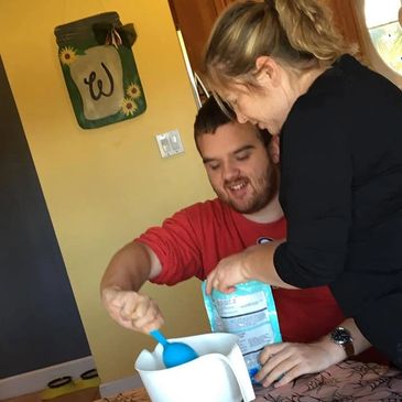 One of our sweet friends using a measuring cup to measure ingredients.