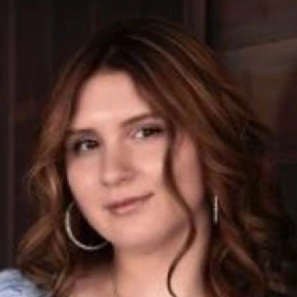 Portrait of a woman with wavy hair and hoop earrings.