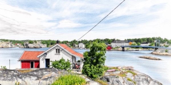 Sjøhus ved kysten med bro og fjord.