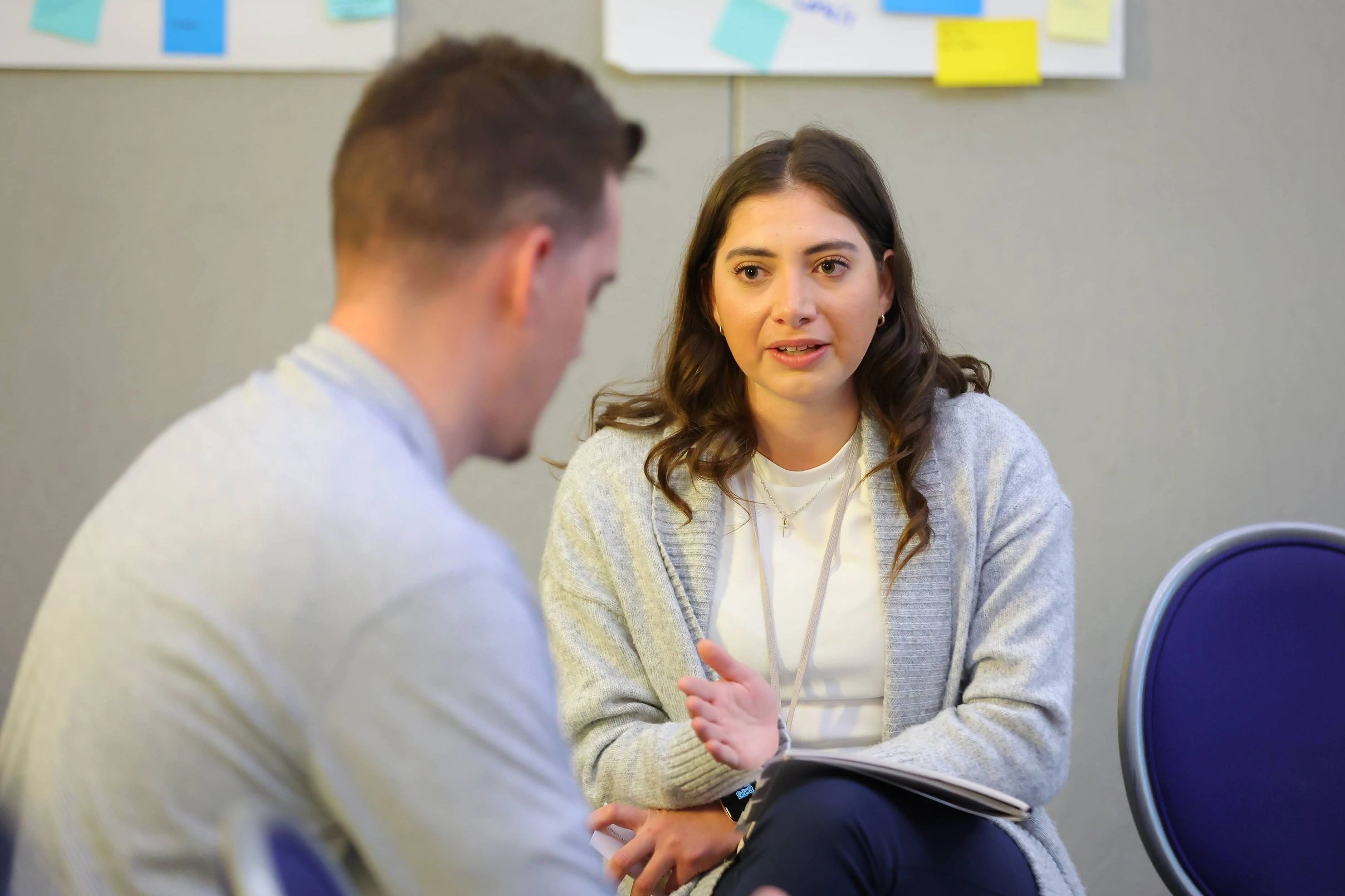 Two people engaged in a serious conversation in an office setting.