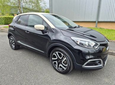 Black compact SUV parked near a building on asphalt.