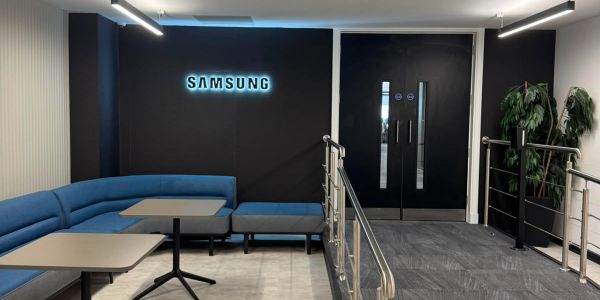 Samsung reception area with blue seating and black walls.