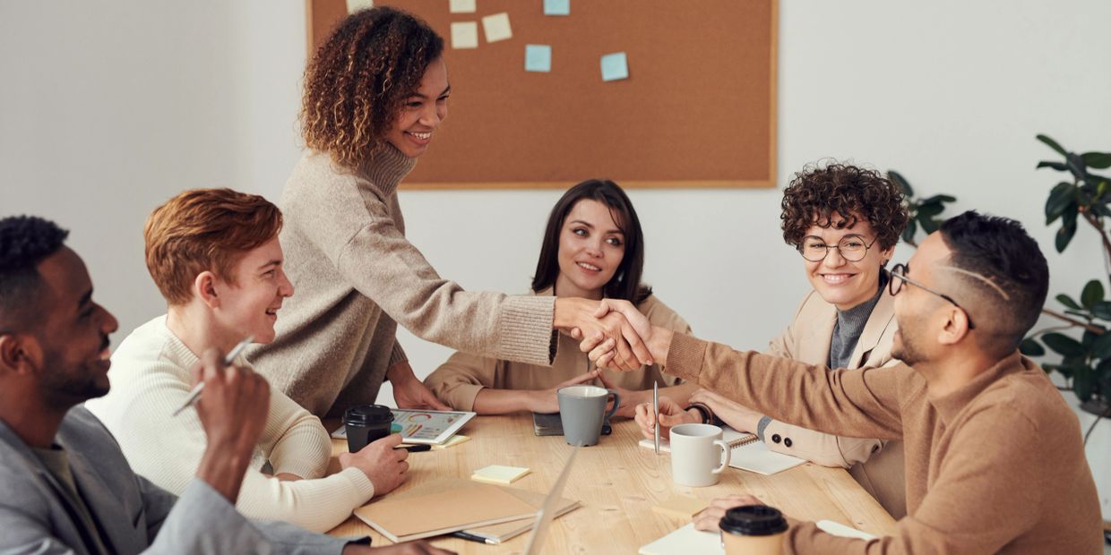 Woman shaking hand with team members
