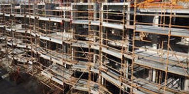 A multi-story building under construction with scaffolding and a crane.