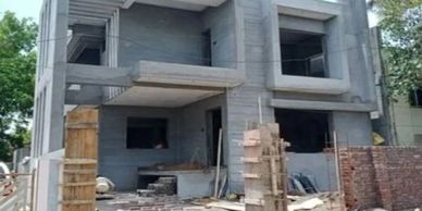 Modern two-story house under construction with concrete structure.